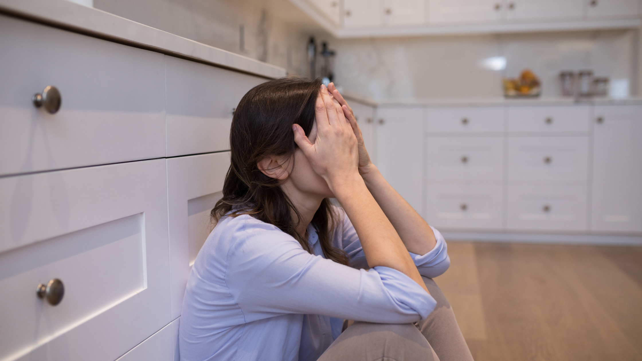 Woman sitting on floor worried about financial uncertainty due to freelancing for money